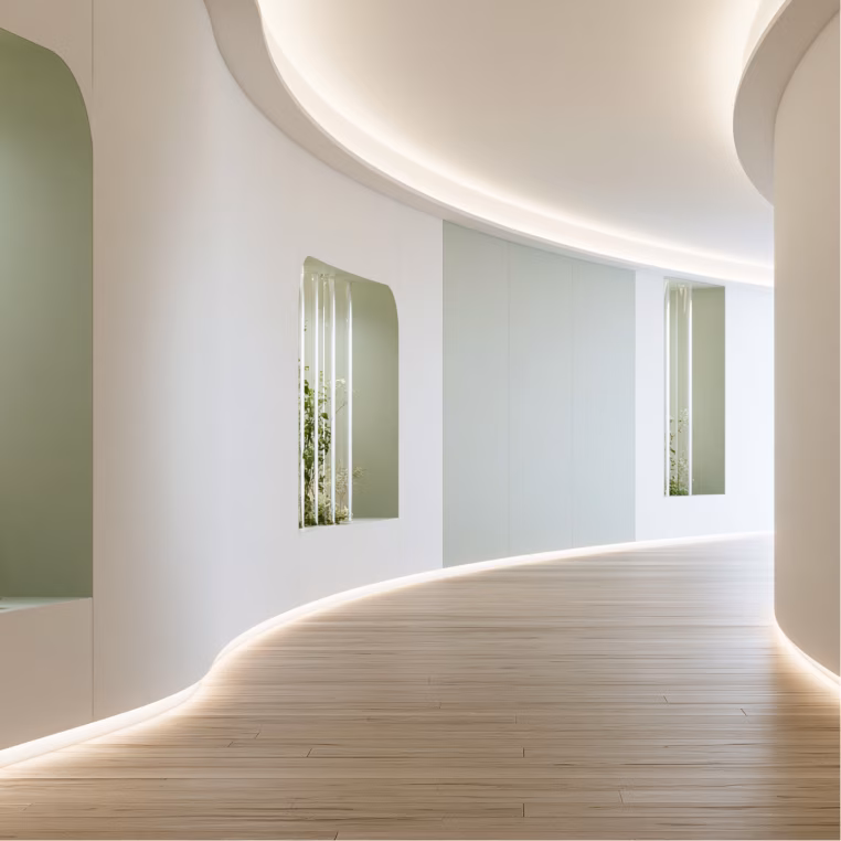 Curved hallway with wood flooring and greenery accents