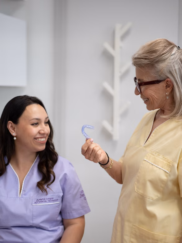 Dental assistant in a surgical cap and mask reviewing an X-ray on a phone