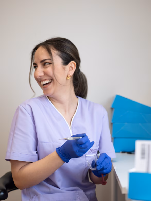 Dentist in a white cap and mask leaning in for a procedure